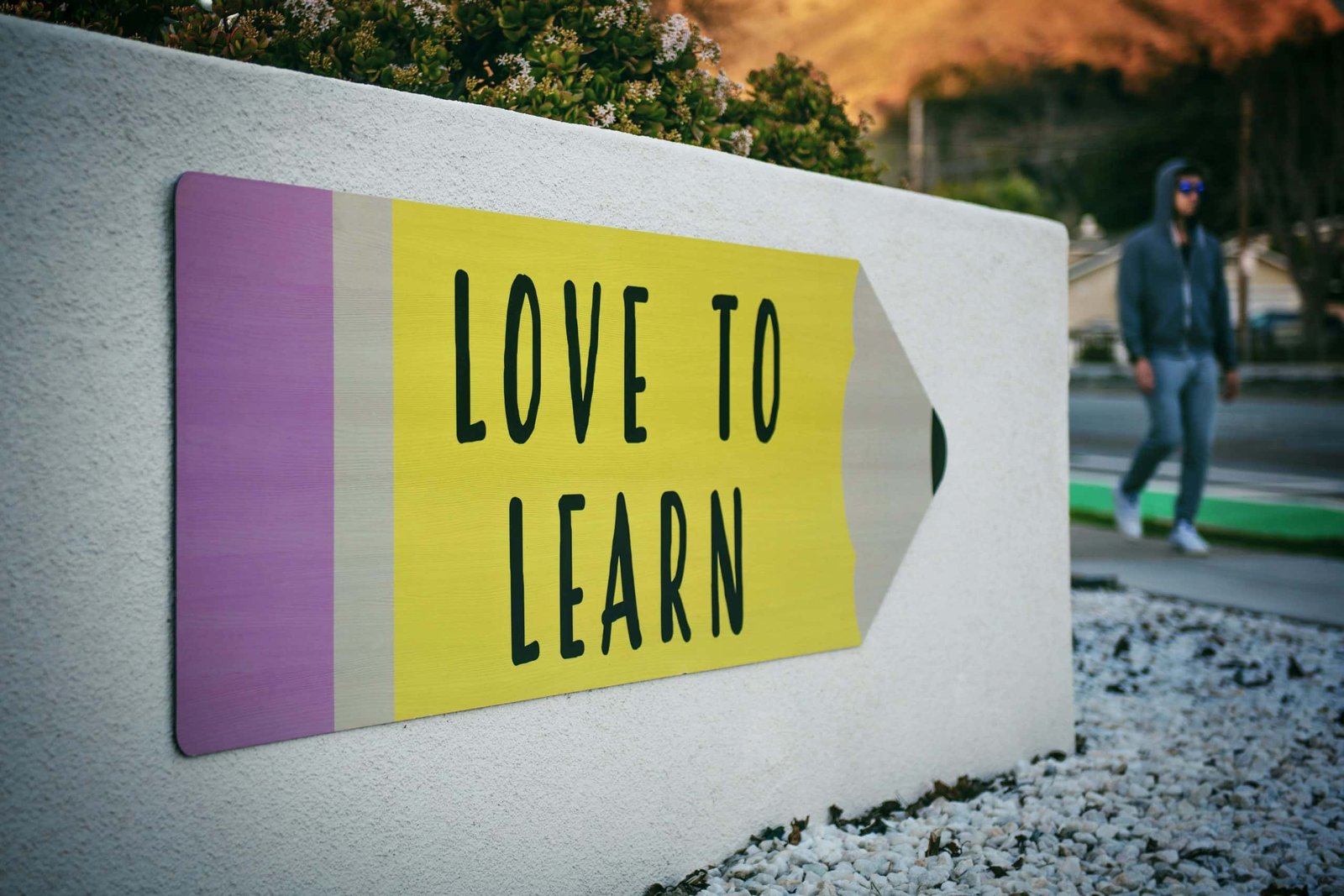 love to learn pencil signage on wall near walking man - ingilizcee.com